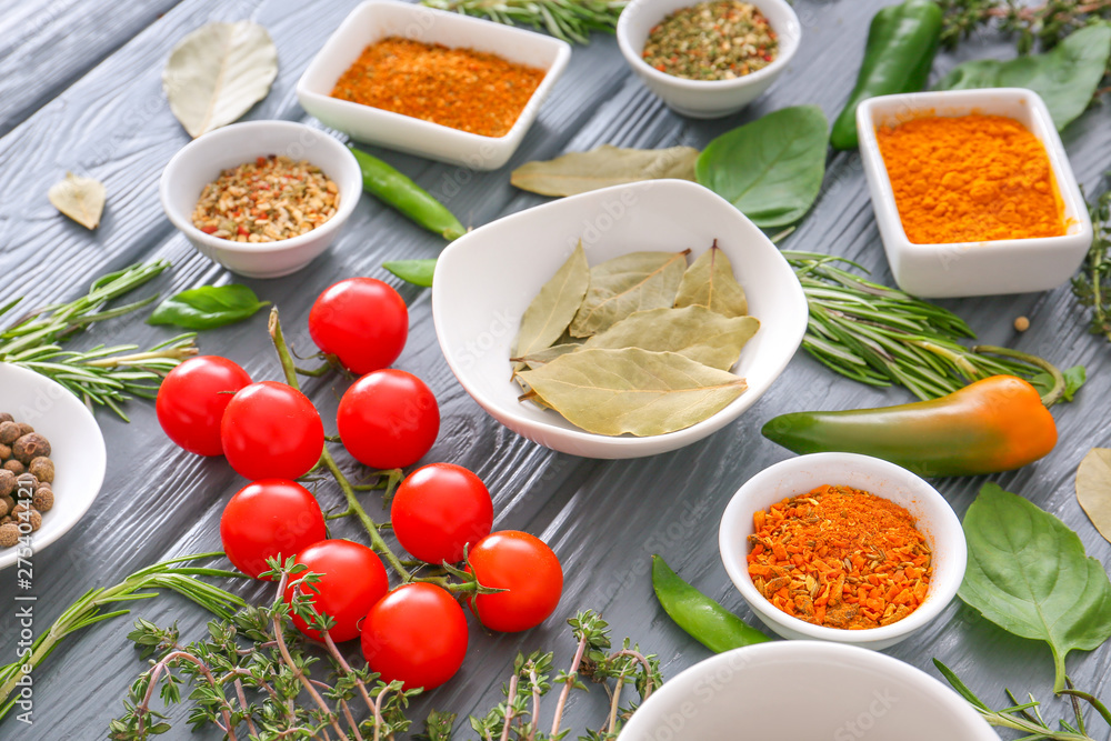 Spices with fresh herbs on wooden table