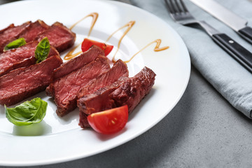 Slices of tasty grilled meat on plate, closeup