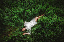 Beautiful Girl Lying On Her Back;  One Girl In The Field; The Girl Lies In The Middle Of A Green Field;  View From Above;  Girl In A White National Shirt; Ukrainian Is In The Field;