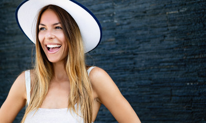 Wall Mural - Beautiful brunette young woman wearing dress and hat, smiling outdoor