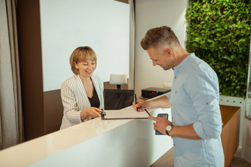 Businessman filling in the form with personal data coming to clinic