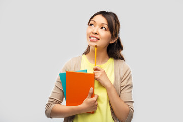 Poster - education, high school and knowledge concept - asian student woman with books and pencil over grey background