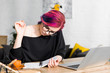 © LIGHTFIELD STUDIOS - girl with colorful hair sitting at table and writing notes in notebook