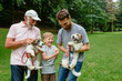 © Iryna - Happy family of father grandfather and son with Jack russel terrier dog having fun, laughing, running, walking together in park. three different generation concept.