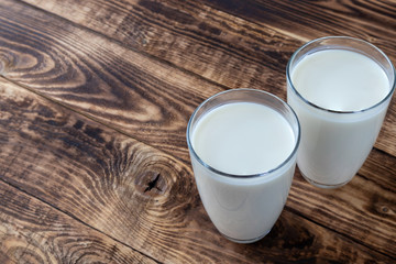 two glasses of milk on a wooden table