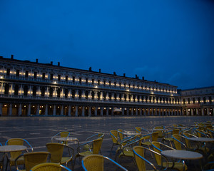 Wall Mural - Photo at sunrise of the old Procuratie seen from the Florian cafe in Piazza San Marco in Venice, Italy. The lights of the portico building of 50 arches, which correspond to the 100 windows of the two 