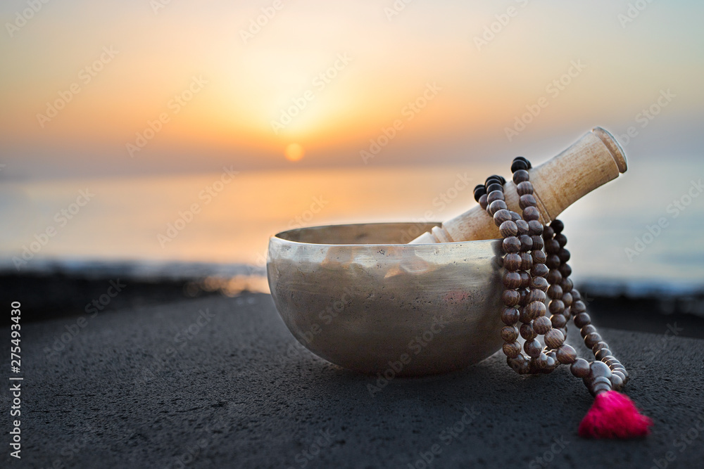 Tibetan bowl with mala beads on nature seaside background for meditation and mindfulness - obrazy, fototapety, plakaty 
