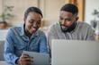 Smiling young African American couple working online together at home