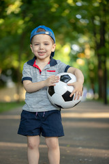 Wall Mural - Little boy play soccer at outdoor.Boy running towards ball on a field