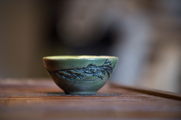 Wall Mural - Green clay cup for Chinese tea on the tea board