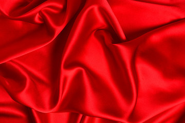 Red silk or satin luxury fabric texture can use as abstract background. Top view.