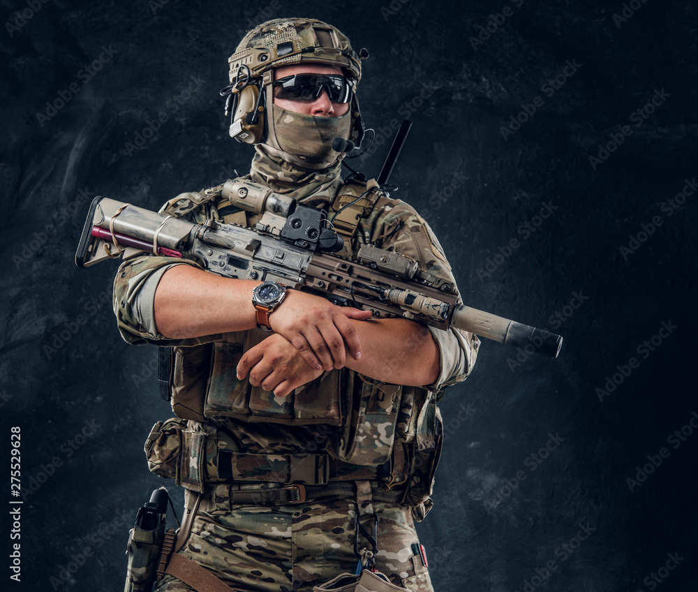 Serious soldier in full gear and military uniform is standing with ...