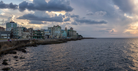 Panoramic view of the Old Havana City, Capital of Cuba, by the ocean coast during a dramatic cloudy sunset.