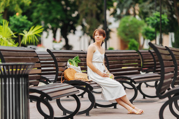 Wall Mural - Woman with reusable water bottle and bamboo handbag, cotton grocery bag with vegetables in park. Summer Vacation concept