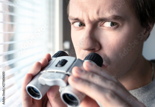 Cuadros en Lienzo Suspicious, skeptic and confused man with binoculars