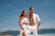 © Detkov D - Fashion photo of a beautiful  fitness happy couple in white clothes in love standing  and posing on the beach. Phuket. Thailand