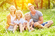 © Robert Kneschke - Happy family is sitting together on a meadow