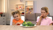 © motortion - Kids looking with disgust at broccoli, unappetizing meal, tasteless healthy food