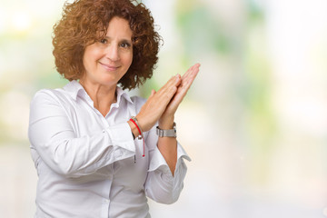 Beautiful middle ager senior businees woman over isolated background Clapping and applauding happy and joyful, smiling proud hands together