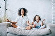 canvas print picture - Cute girl and mother meditating on couch