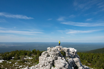 a man in a bright jacket stands on top of a mountain. The scale of the planet. freedom