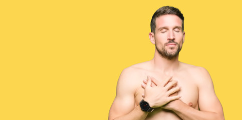 Handsome shirtless man showing nude chest smiling with hands on chest with closed eyes and grateful gesture on face. Health concept.