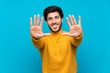 © luismolinero - Handsome over isolated blue wall counting ten with fingers