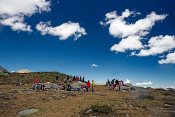 Wall Mural - hikers stop on a high mountain meadow.
