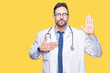 © Krakenimages.com - Handsome young doctor man over isolated background Swearing with hand on chest and open palm, making a loyalty promise oath
