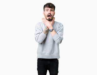 Poster - Young handsome man wearing sweatshirt over isolated background shouting and suffocate because painful strangle. Health problem. Asphyxiate and suicide concept.