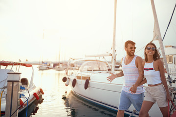 Couple walking near the yachts on the dock..