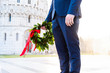 © Polonio Video - Giovane laureato con corona d'alloro verde e nastro rosso tenuto in mano. Cerimonia di laurea.