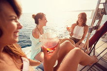 Group Of Friend’s Girl Having Party On Sailing Boat And Drinking Wine.