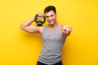 © luismolinero - Handsome sport man over isolated background with kettlebell