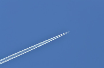 Fototapete - Flugzeug mit Kondensstreifen am blauen Himmel