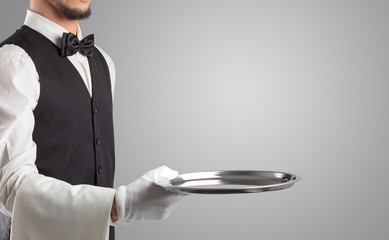 Wall Mural - Waiter serving with white gloves and steel tray in an empty space
