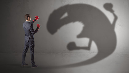 Canvas Print - Businessman with boxing glove fighting with a big monster shadow
