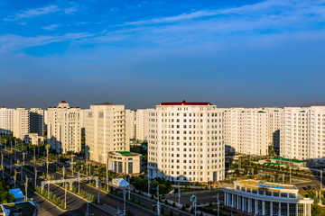 Friday, 28 June 2019; Ashgabat, Turkmenistan; beautiful cityscape view on a highway and white marble residential towers at afternoon in a sunny day.