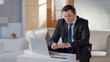 © motortion - Young financier checking company report, working on laptop in modern office