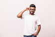 © F8  \ Suport Ukraine - Charming handsome. Confident young Indian man adjusting his eyeglasses and smiling while standing against white background