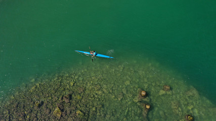 Aerial drone photo of young men competing with sport canoe in tropical lake with calm waters