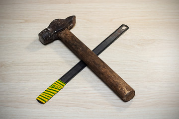 Hammer and saw closeup on a wooden table, repair idea