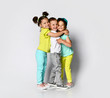 © FAB.1 - Studio portrait of children on a light background: full body shot of three children in bright clothes, two girls and one boy.