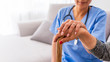 © Dragana Gordic - Young carer supporting senior disabled woman with walking stick. Senior woman with her caregiver at home. Concept senior people health care. Senior Woman's Hands On Walking Stick