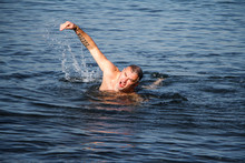 Adult Man With A Beard Weary Swims In A Stormy Blue Sea
