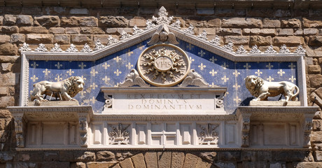 Wall Mural - Medallion with the IHS monogram between two lions, above to the entrance to Palazzo Vecchio, a UNESCO World Heritage Site in Florence, Italy