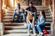 © Тарас Нагирняк - Group of young attractive smiling students dressed casual sitting on the staircase outdoors on campus at the university.