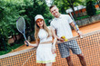 © Тарас Нагирняк - Happy couple after playing tennis on court. Portrait of smiling young man and beautiful woman with tennis rackets ..
