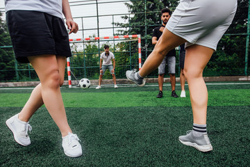 Wall Mural - Close up photo of boy puts  and girls his leg on ball on soccer field. Training, active lifestyle, sport, children activity concept