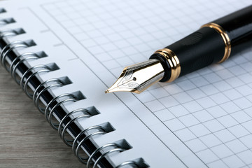 Wall Mural - fountain pen on the notepad on a wooden table